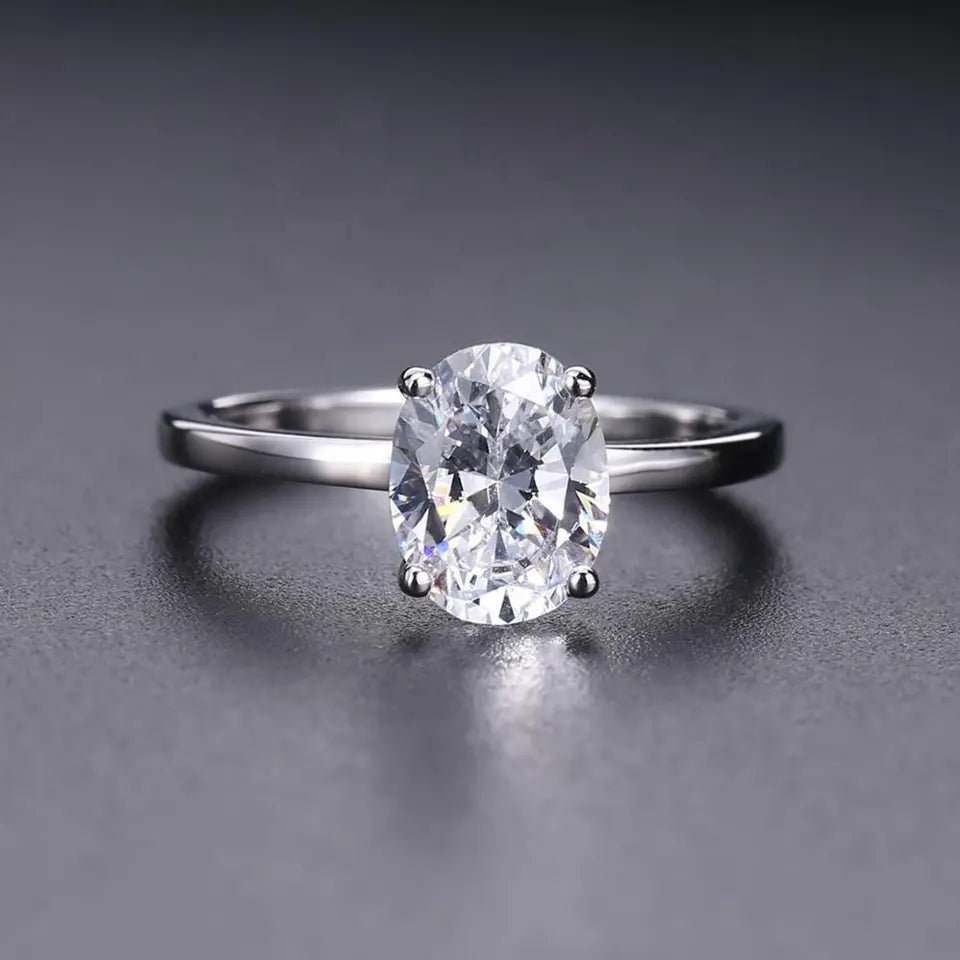 A stunning engagement ring with a 2.00ct oval moissanite center stone, presented in a classic four-prong setting, crafted from high-quality sterling silver.
