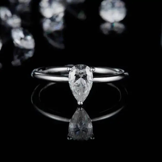 This sterling silver engagement ring showcases a 1.00ct pear-shaped moissanite secured by a traditional claw setting for a timeless look.