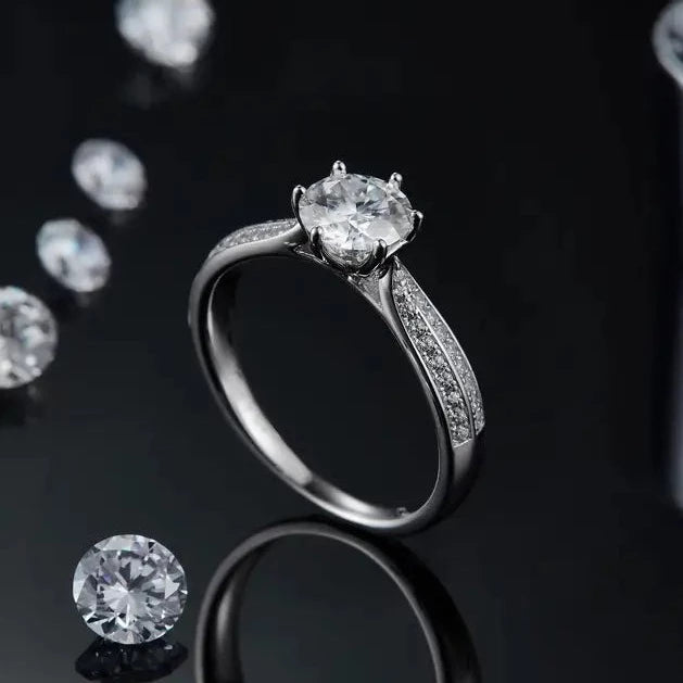 A beautifully crafted sterling silver engagement ring with a brilliant moissanite center stone and a pave-set band for added brilliance.