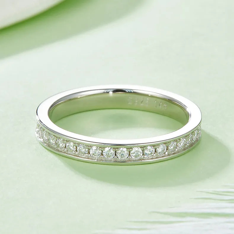 A detailed view showcasing the intricate pavé setting and the brilliance of the moissanite stones around the entire circumference of the ring.