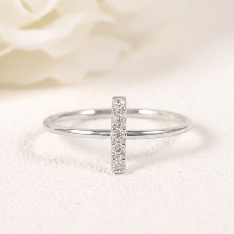 Silver ring with small diamonds on a soft white fabric background