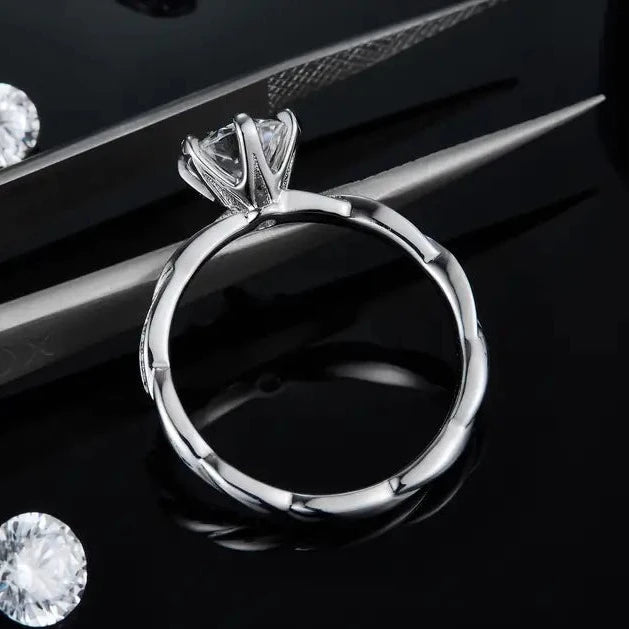 A detailed sterling silver engagement ring showcasing a 1.00ct moissanite, enriched with vintage-inspired elements.