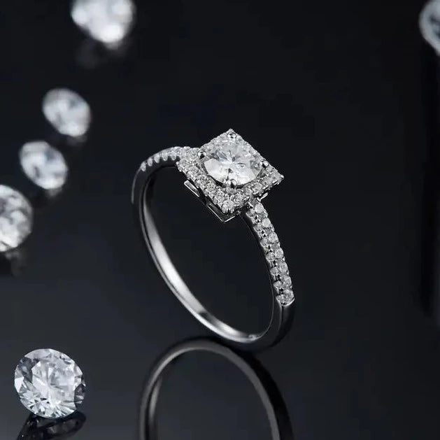 A sparkling halo of stones surrounds a brilliant 0.50ct center stone in this 9ct white gold ring.