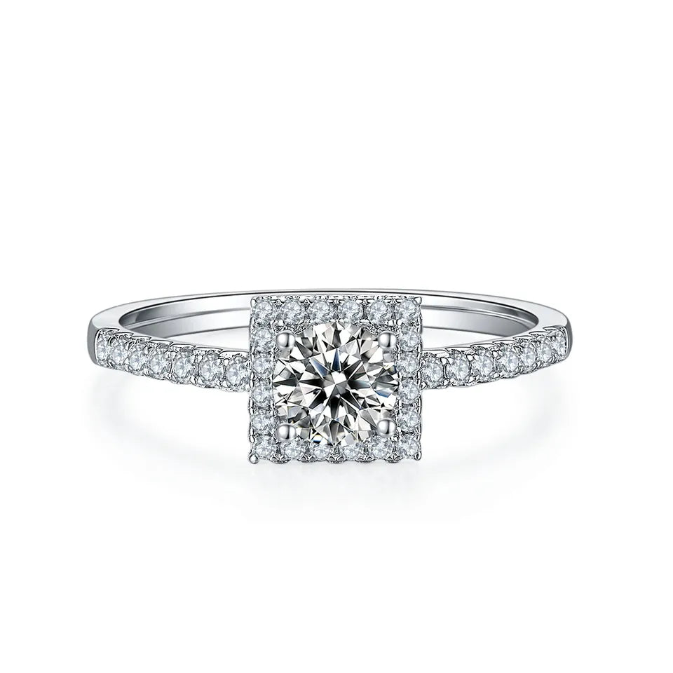 This beautiful ring showcases a sparkling 0.50ct moissanite with a halo setting, crafted in polished sterling silver.