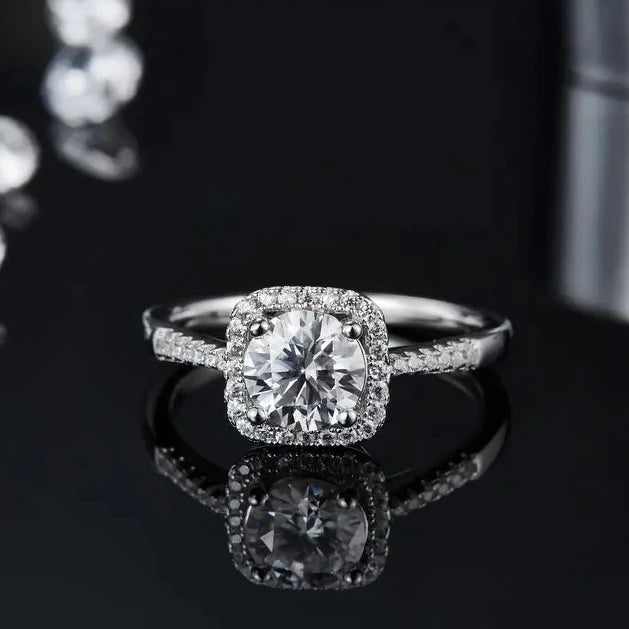 A side view showcasing the elegant profile of this sterling silver engagement ring, featuring a 1.00ct moissanite and halo setting.