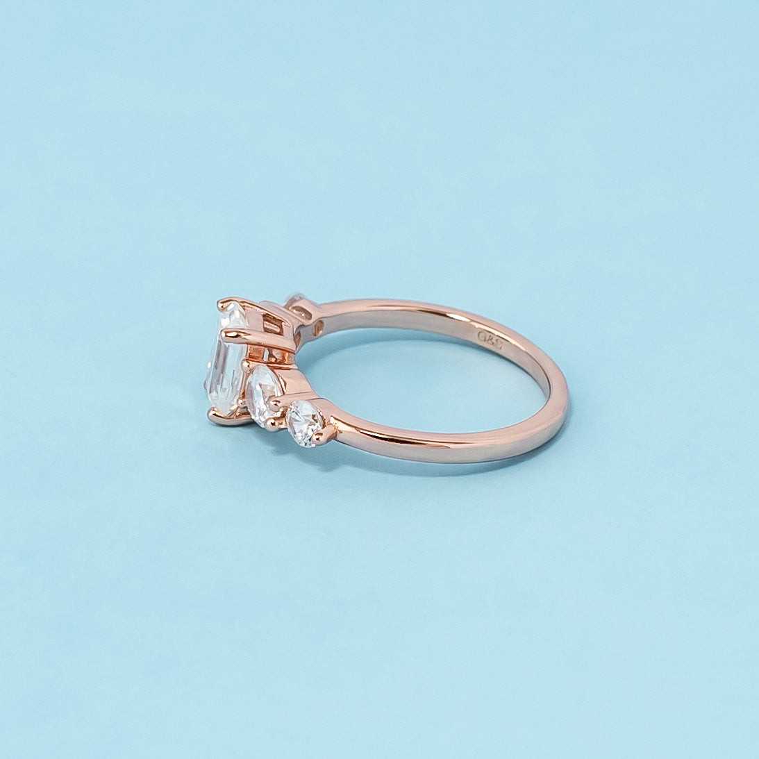 Elegant rose gold engagement ring showcasing five sparkling emerald cut moissanites in a classic design.