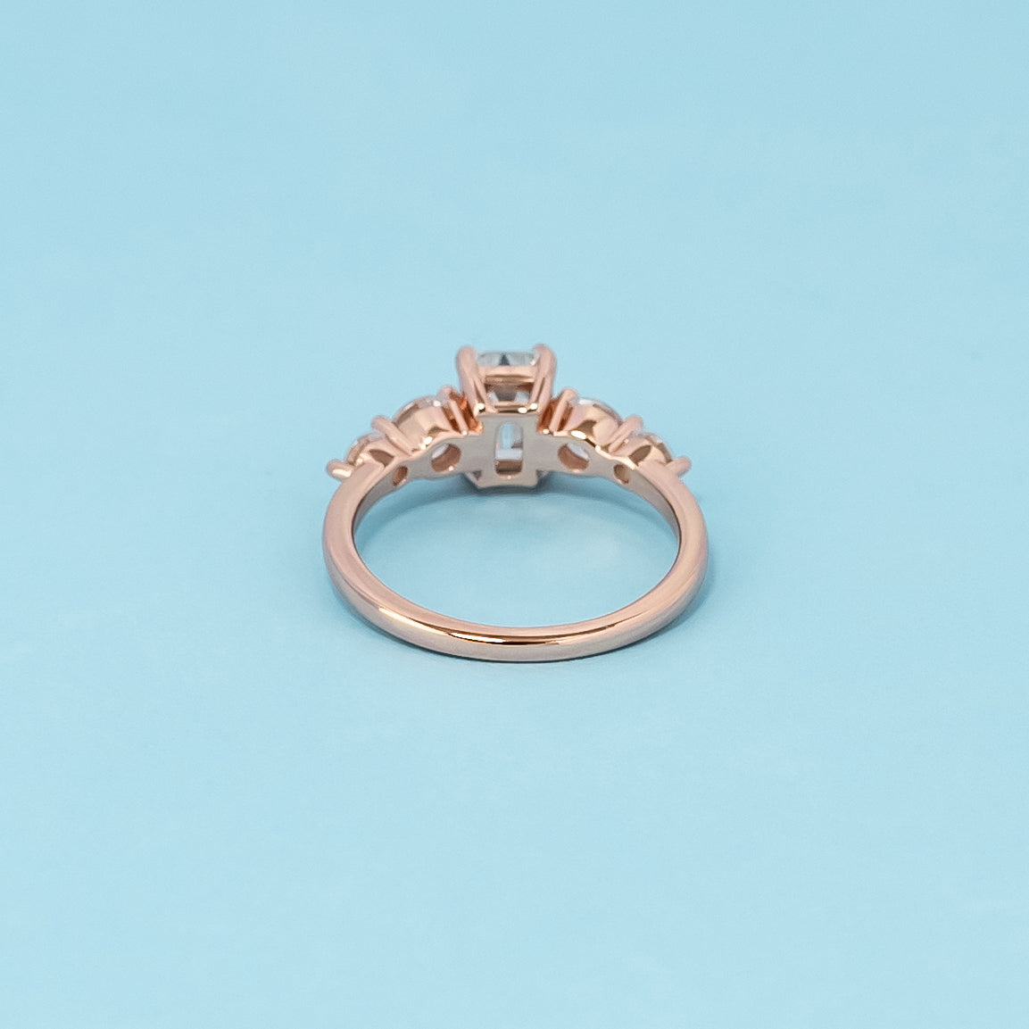 Luxurious 9ct rose gold engagement ring set with five beautiful emerald cut moissanites, symbolizing enduring love and brilliance.