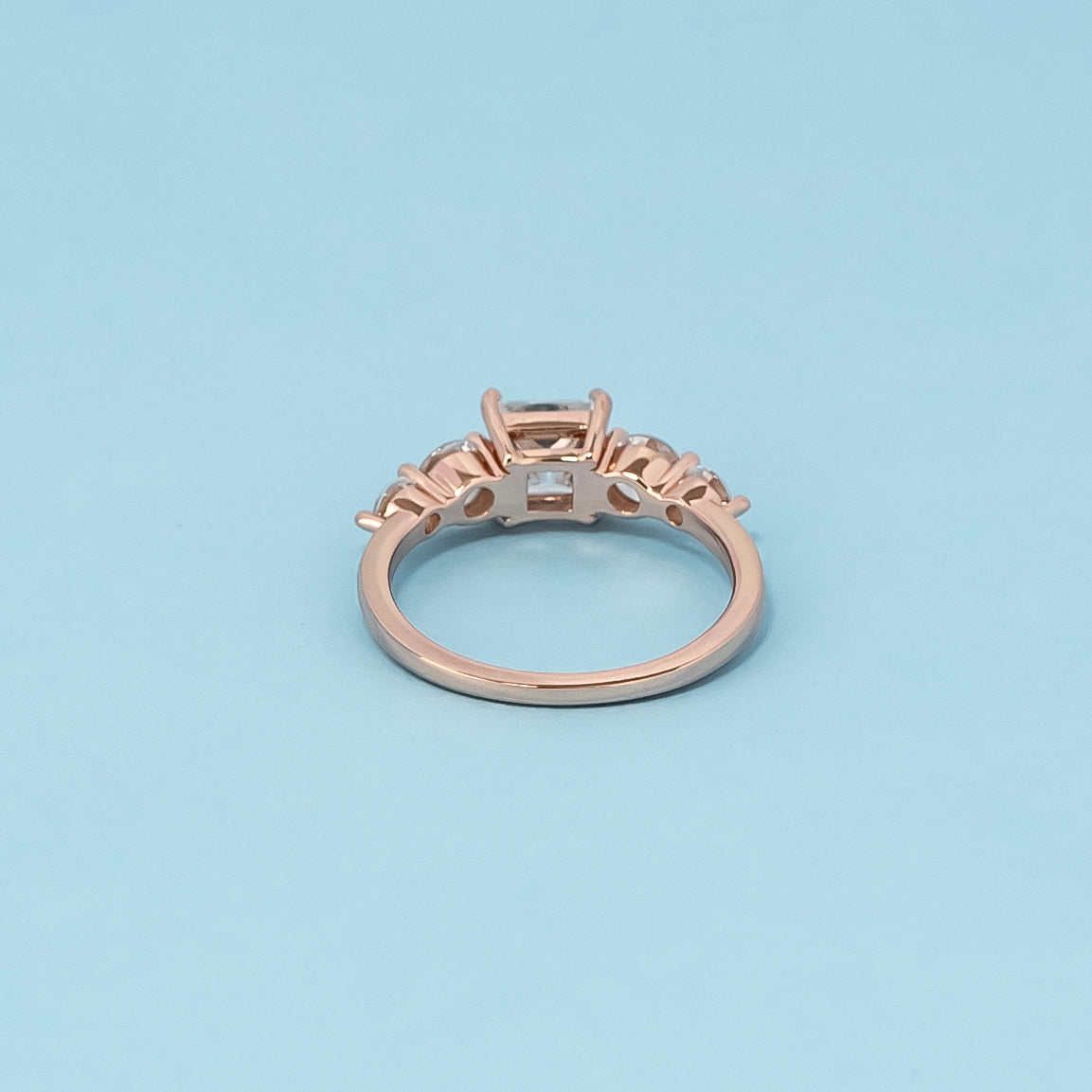 Luxurious 9ct rose gold engagement ring set with five beautiful princess cut moissanites, symbolizing enduring love and brilliance.