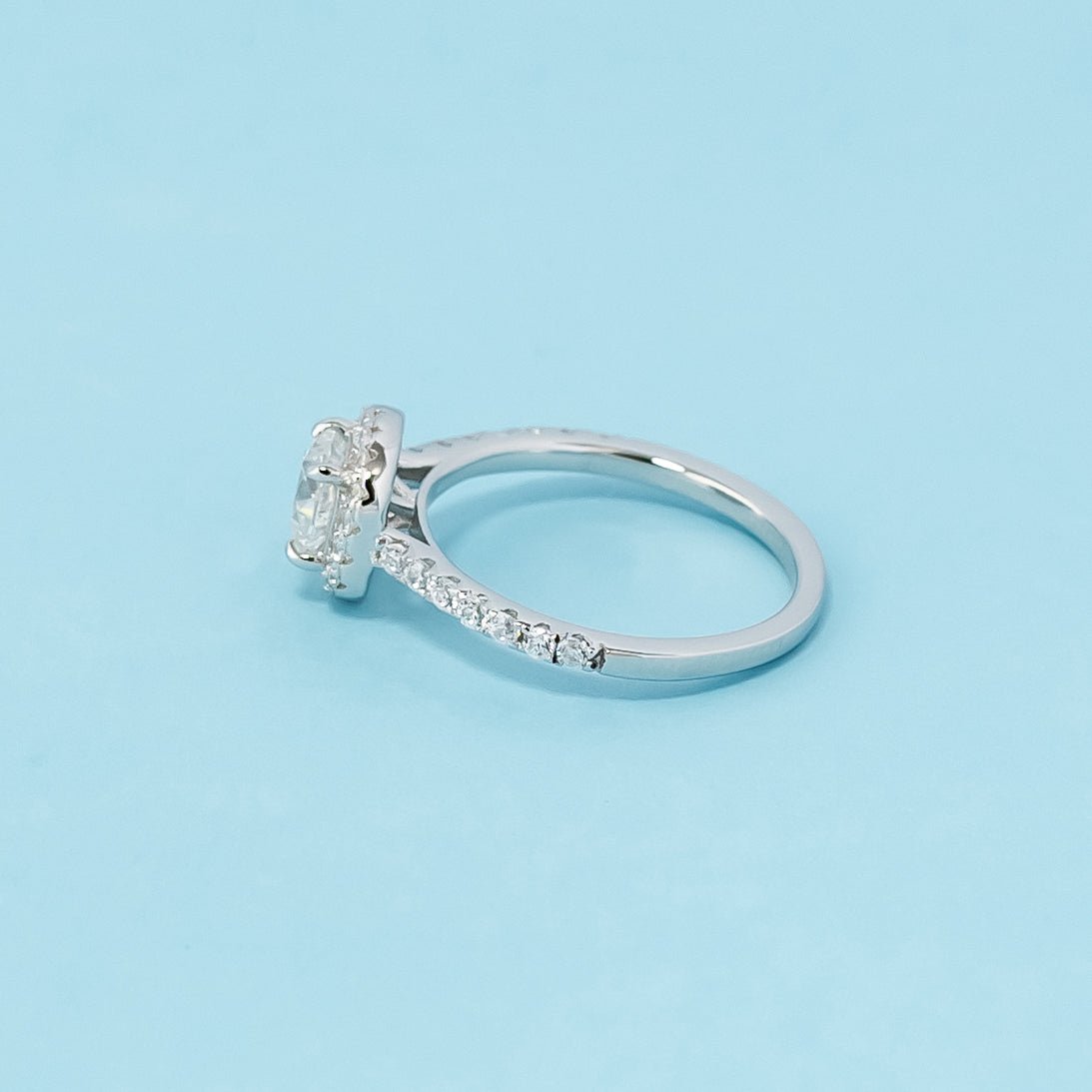 Timeless and sophisticated engagement ring showcasing a cushion cut moissanite in a beautiful halo design, crafted in 9ct white gold.