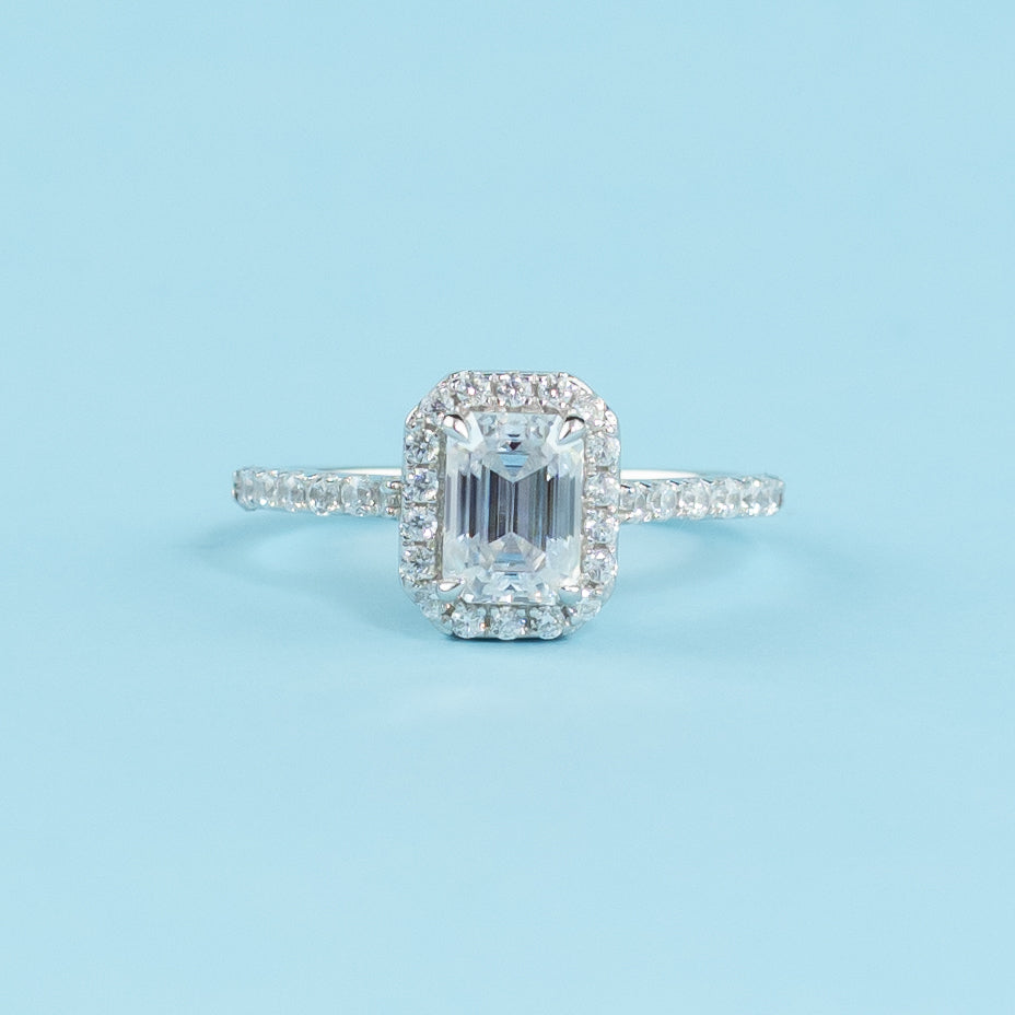 Elegant 9ct white gold engagement ring featuring an emerald cut moissanite surrounded by a classic halo.