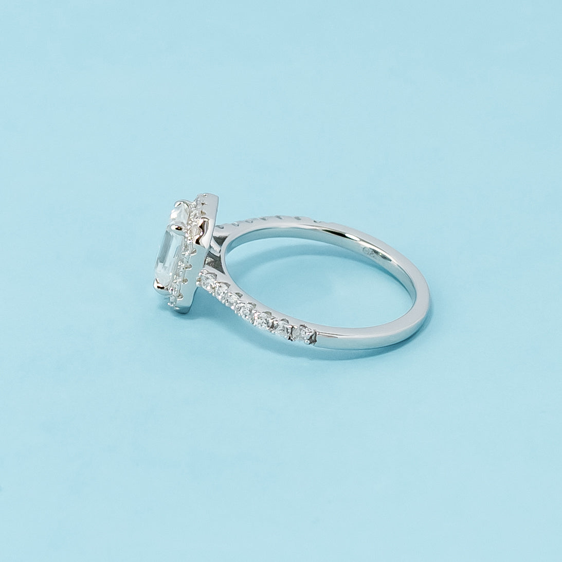 Timeless and sophisticated engagement ring showcasing an emerald cut moissanite in a beautiful halo setting, crafted in 9ct white gold.