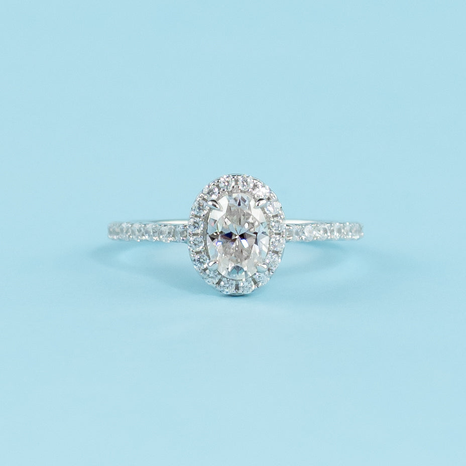 Elegant 9ct white gold engagement ring featuring an oval cut moissanite surrounded by a classic halo setting.