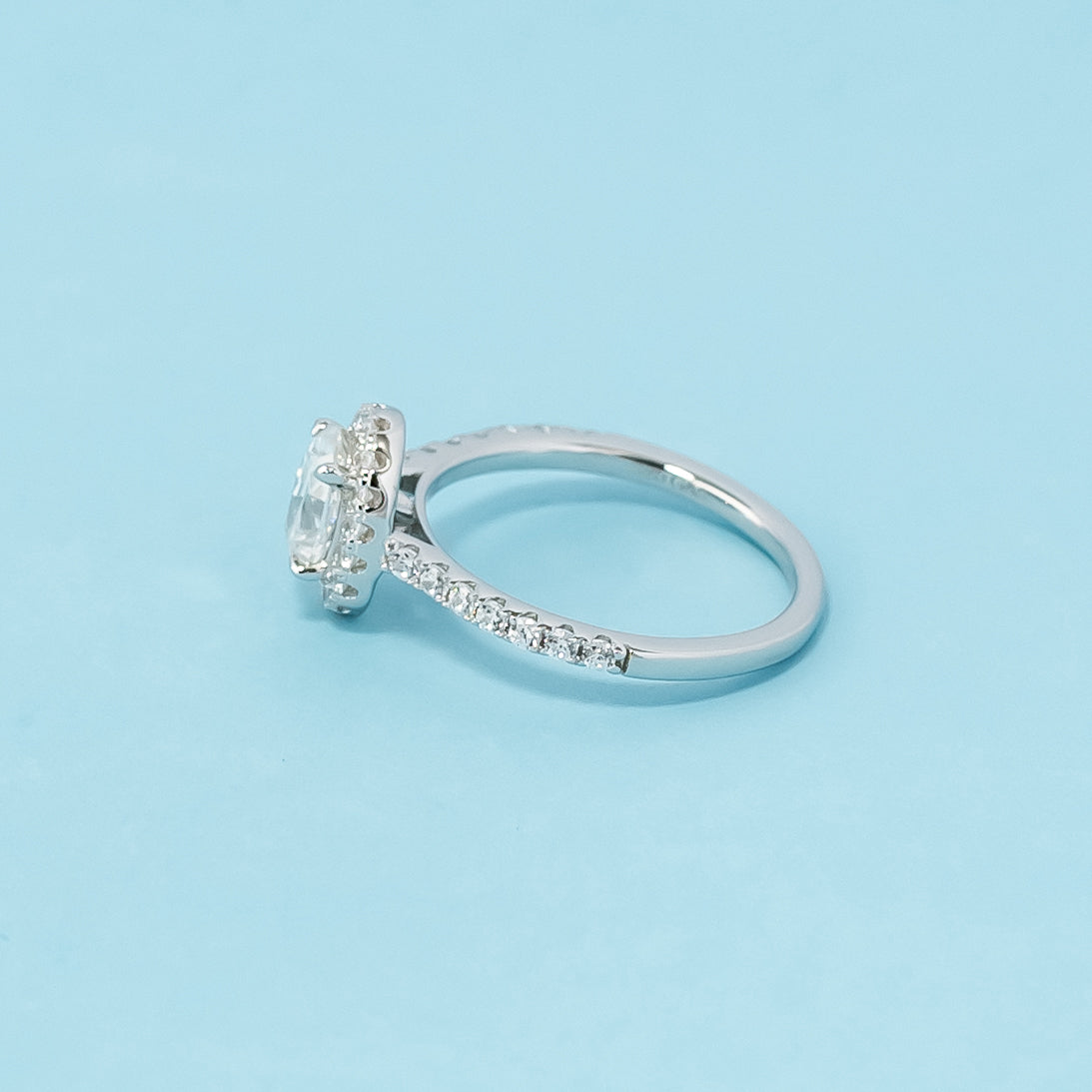 Timeless and sophisticated engagement ring showcasing an oval cut moissanite in a beautiful halo design, crafted in 9ct white gold.