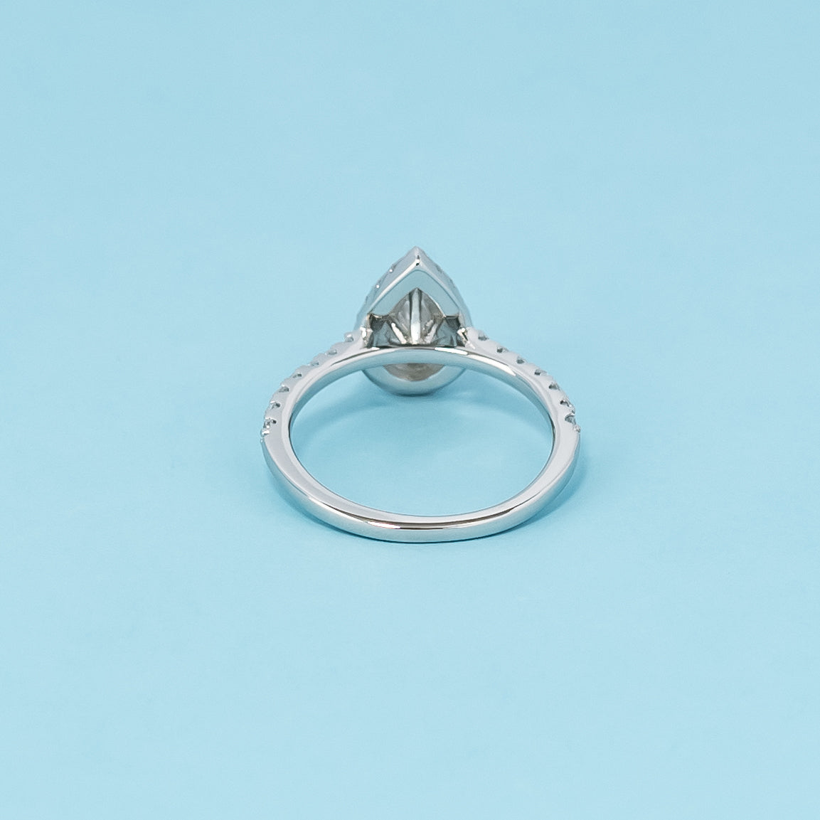 Luxurious 9ct white gold engagement ring with a classic halo setting that enhances the brilliance of the pear-shaped moissanite.