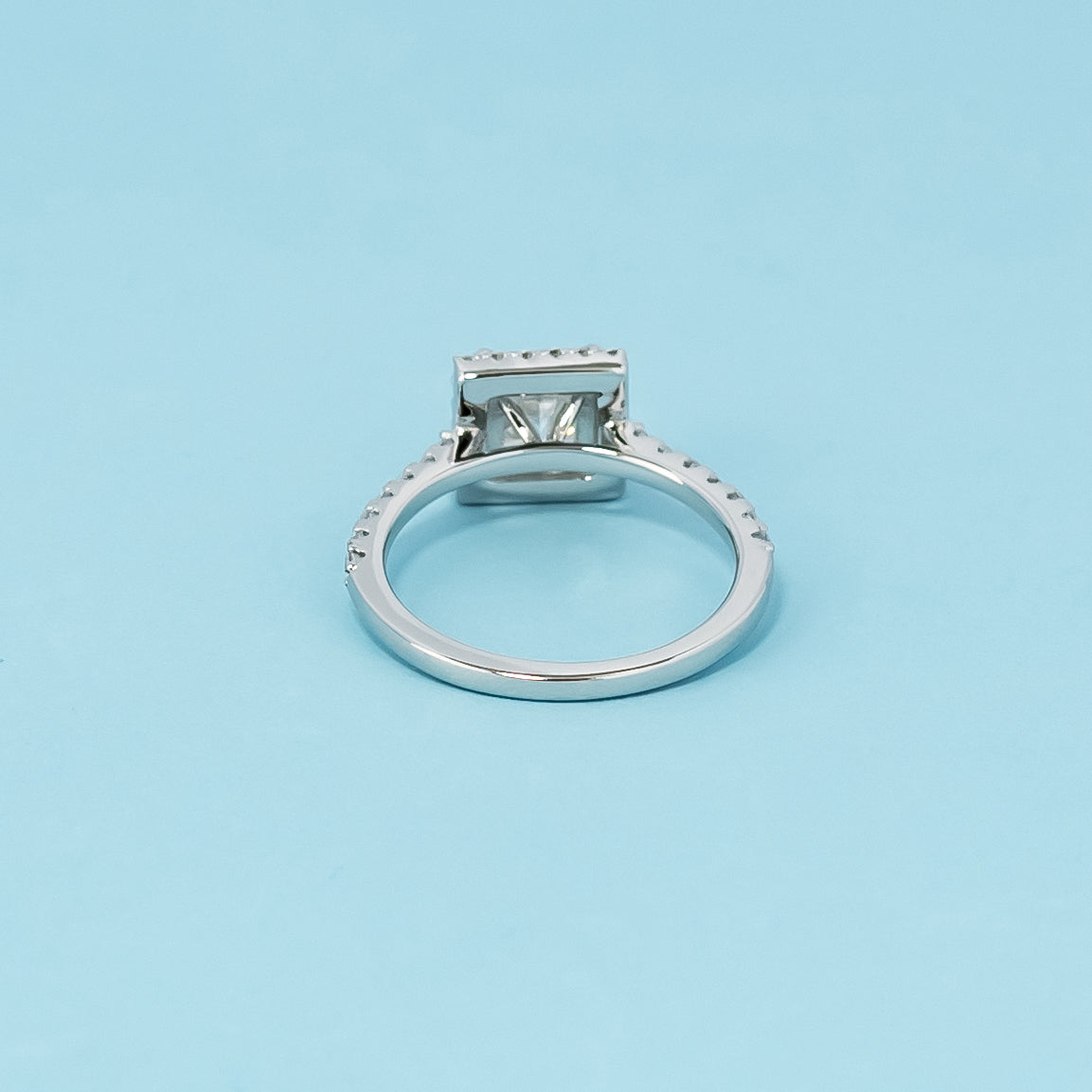 Luxurious 9ct white gold engagement ring with a classic halo setting that enhances the brilliance of the princess cut moissanite.