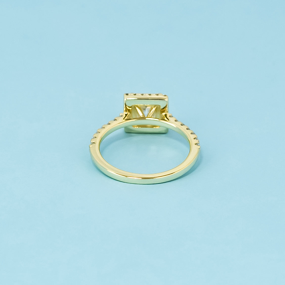 This elegant 9ct yellow gold ring features a princess cut moissanite with a classic halo, perfect for a timeless engagement.