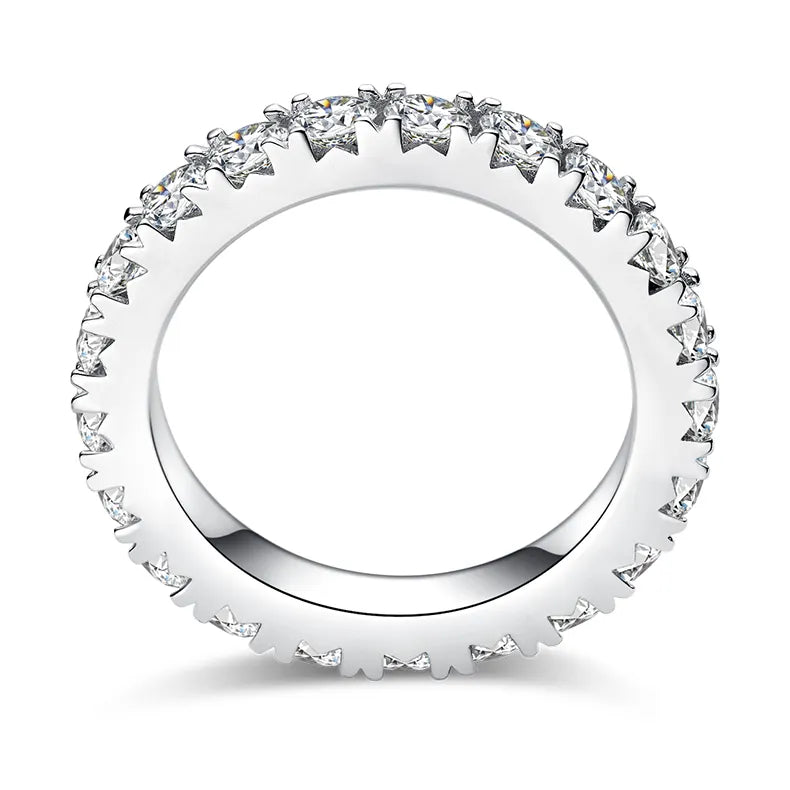 A thin ring with a full circle of gemstones, shown on its own.