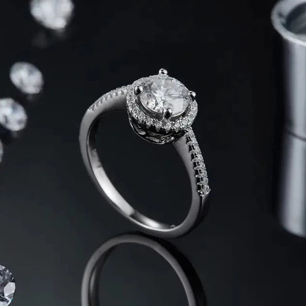 A stylish and meaningful engagement ring featuring a 1.00ct moissanite framed by a delicate and romantic heart-shaped halo in sterling silver.