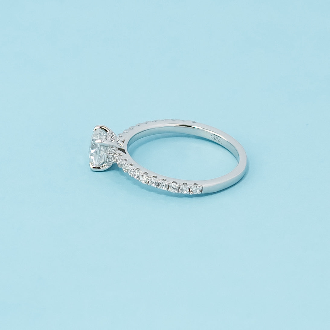 Modern and sophisticated engagement ring showcasing a cushion cut moissanite in a unique hidden setting, crafted in 9ct white gold.
