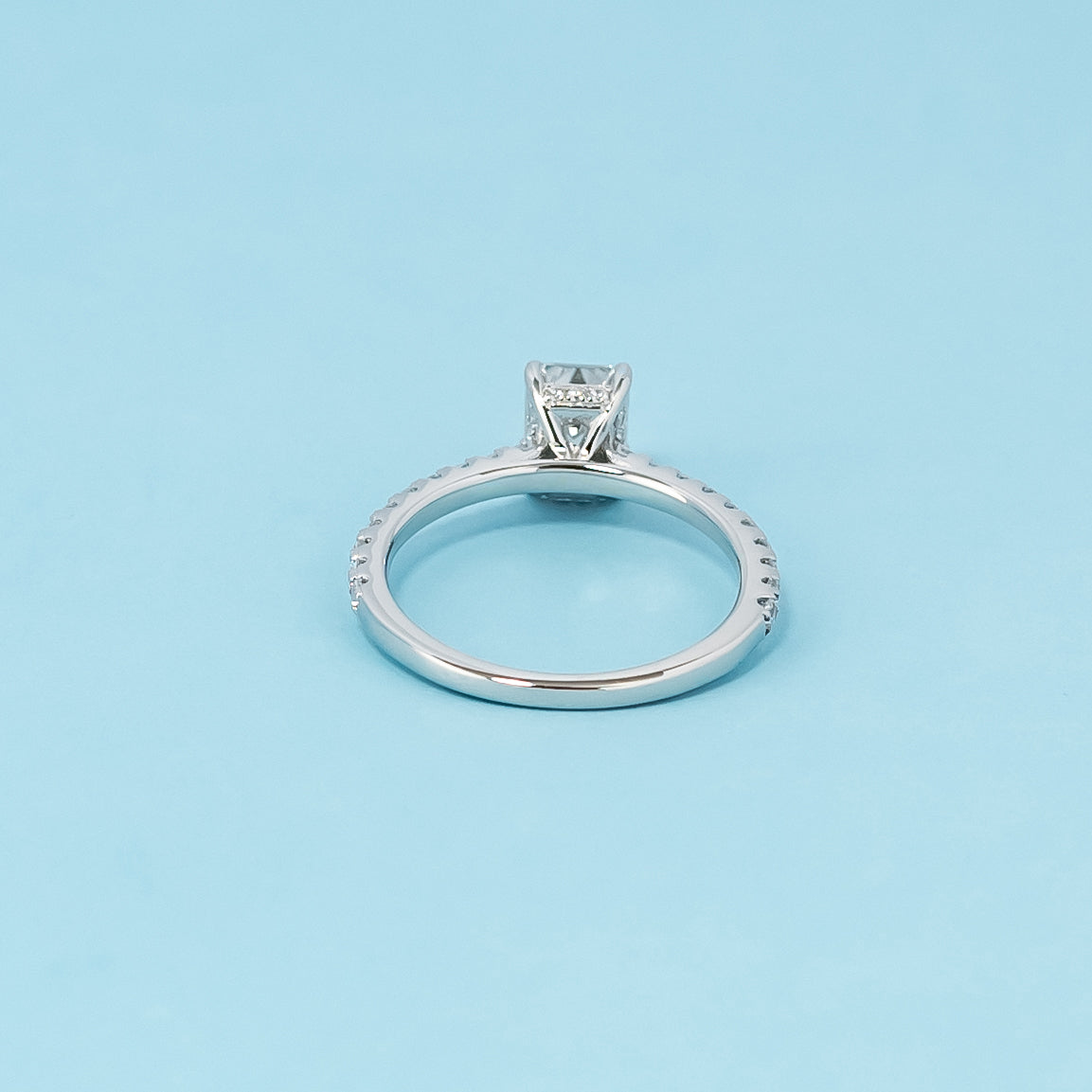Luxurious 9ct white gold engagement ring with a beautifully concealed setting that highlights the brilliance of the emerald cut moissanite.