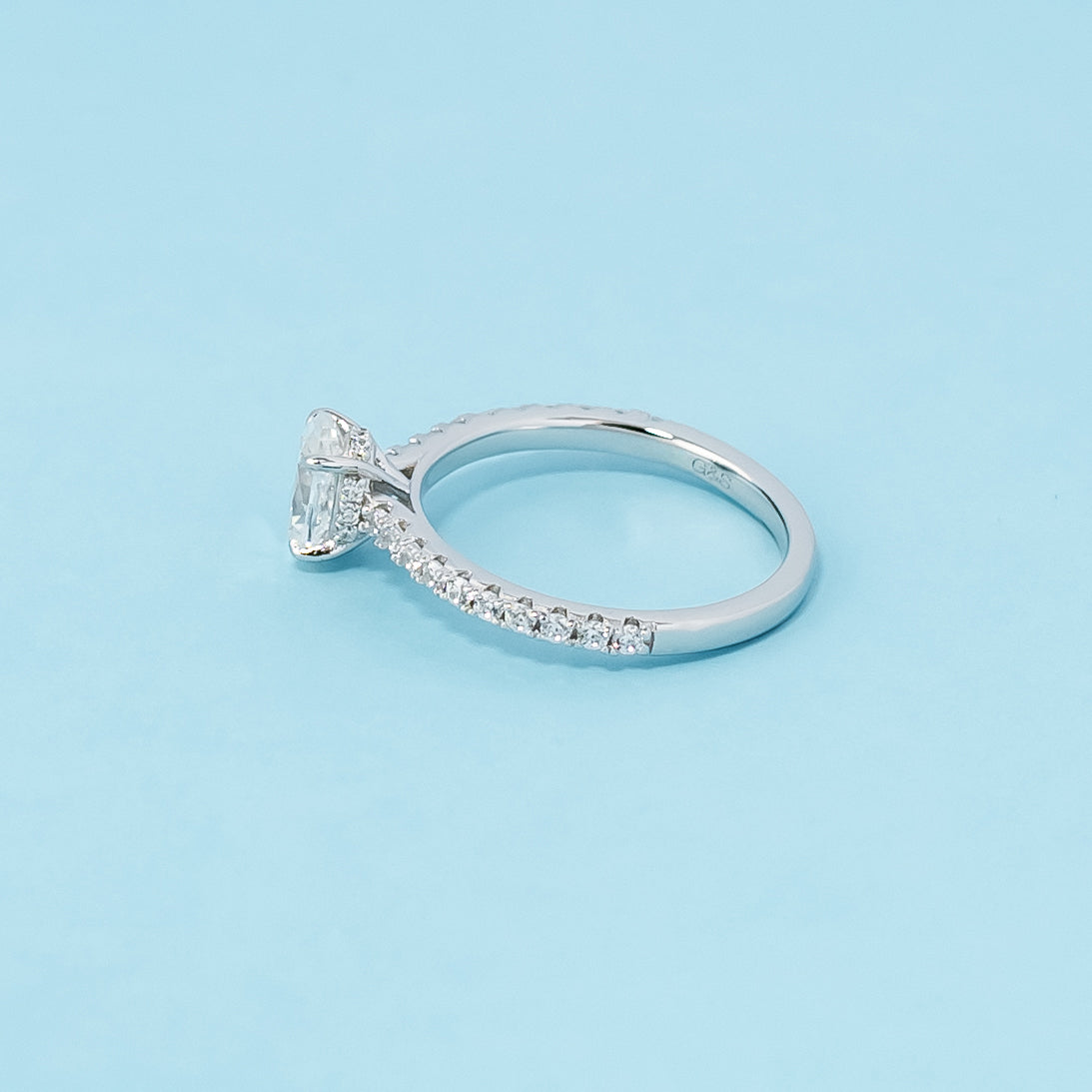 Modern and sophisticated engagement ring showcasing an oval cut moissanite in a unique hidden setting, crafted in 9ct white gold.