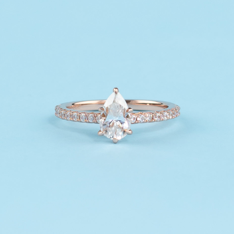 Elegant pear-cut moissanite engagement ring with a hidden halo setting in warm 9ct rose gold.