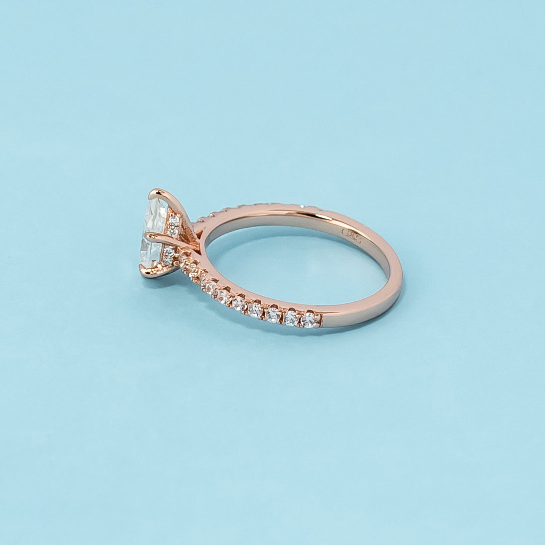 Stunning rose gold engagement ring featuring a sparkling pear-shaped moissanite and a unique hidden design.