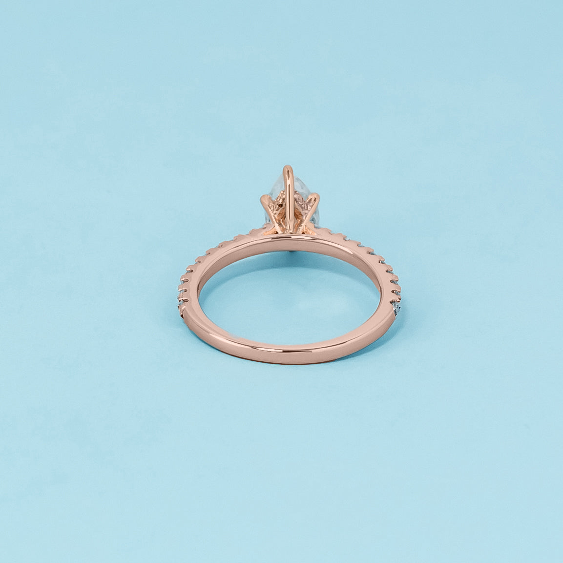 Luxurious 9ct rose gold engagement ring showcasing a beautiful pear-shaped moissanite with a subtle hidden halo.