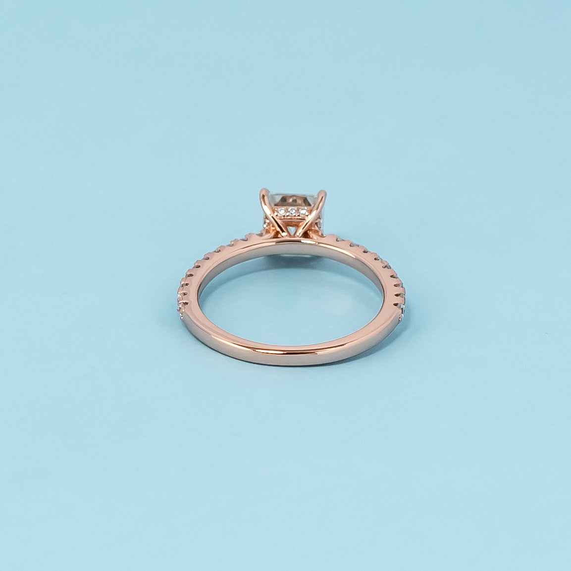 Luxurious 9ct rose gold engagement ring showcasing a brilliant princess cut moissanite with a subtle hidden halo setting.