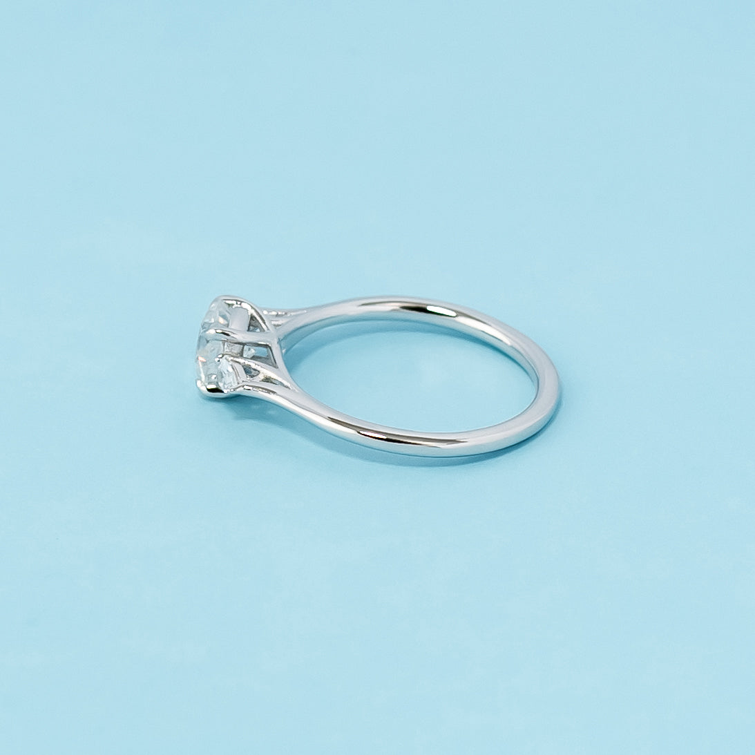Modern and symbolic engagement ring set in 9ct white gold, showcasing cushion cut moissanites representing past, present, and future love.