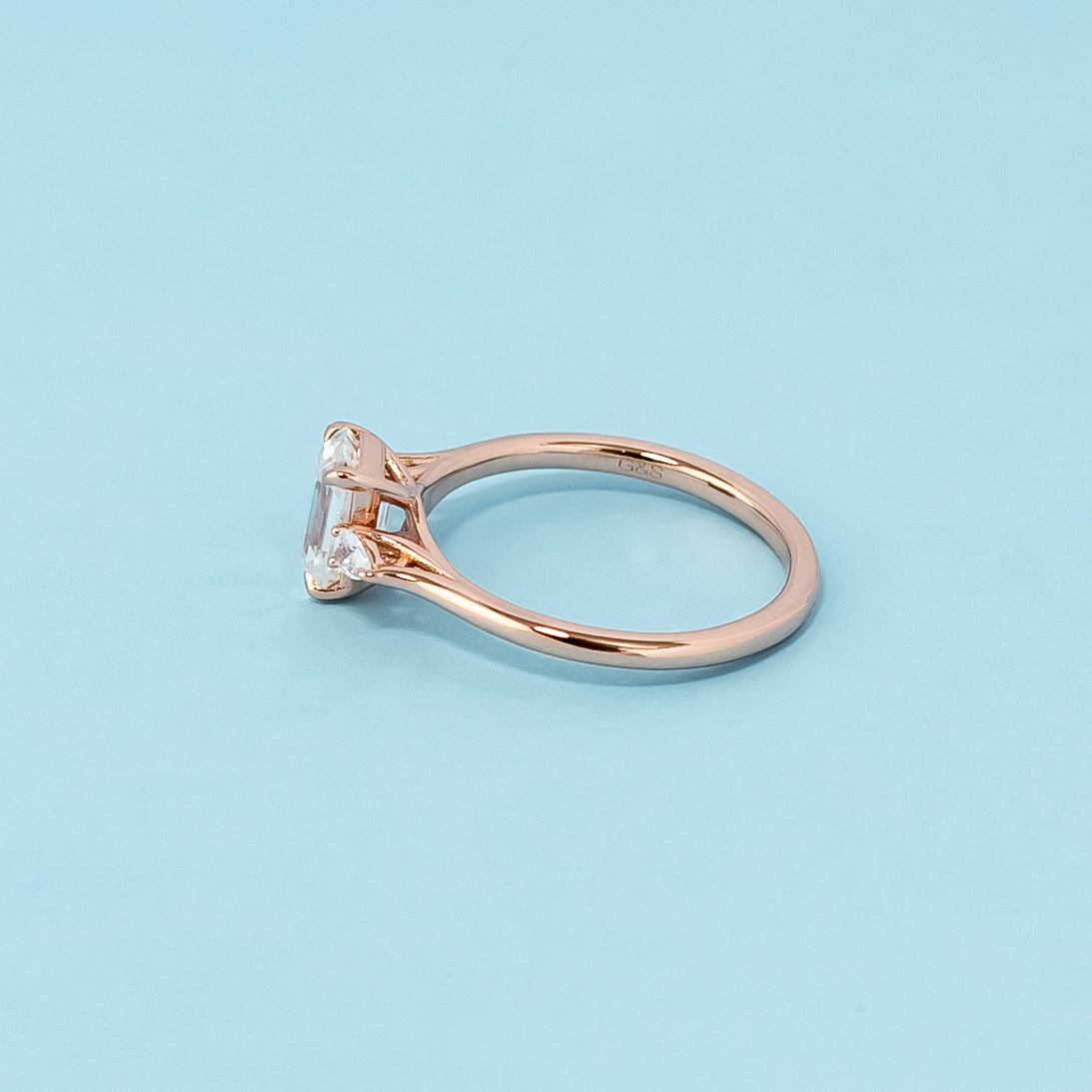 Elegant rose gold engagement ring showcasing three sparkling emerald cut moissanites in a classic trilogy design.
