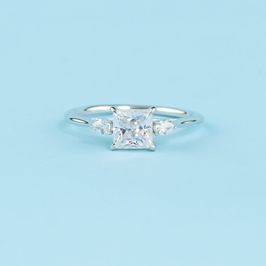 Elegant 9ct white gold engagement ring with a trilogy design, showcasing three sparkling princess cut moissanites.