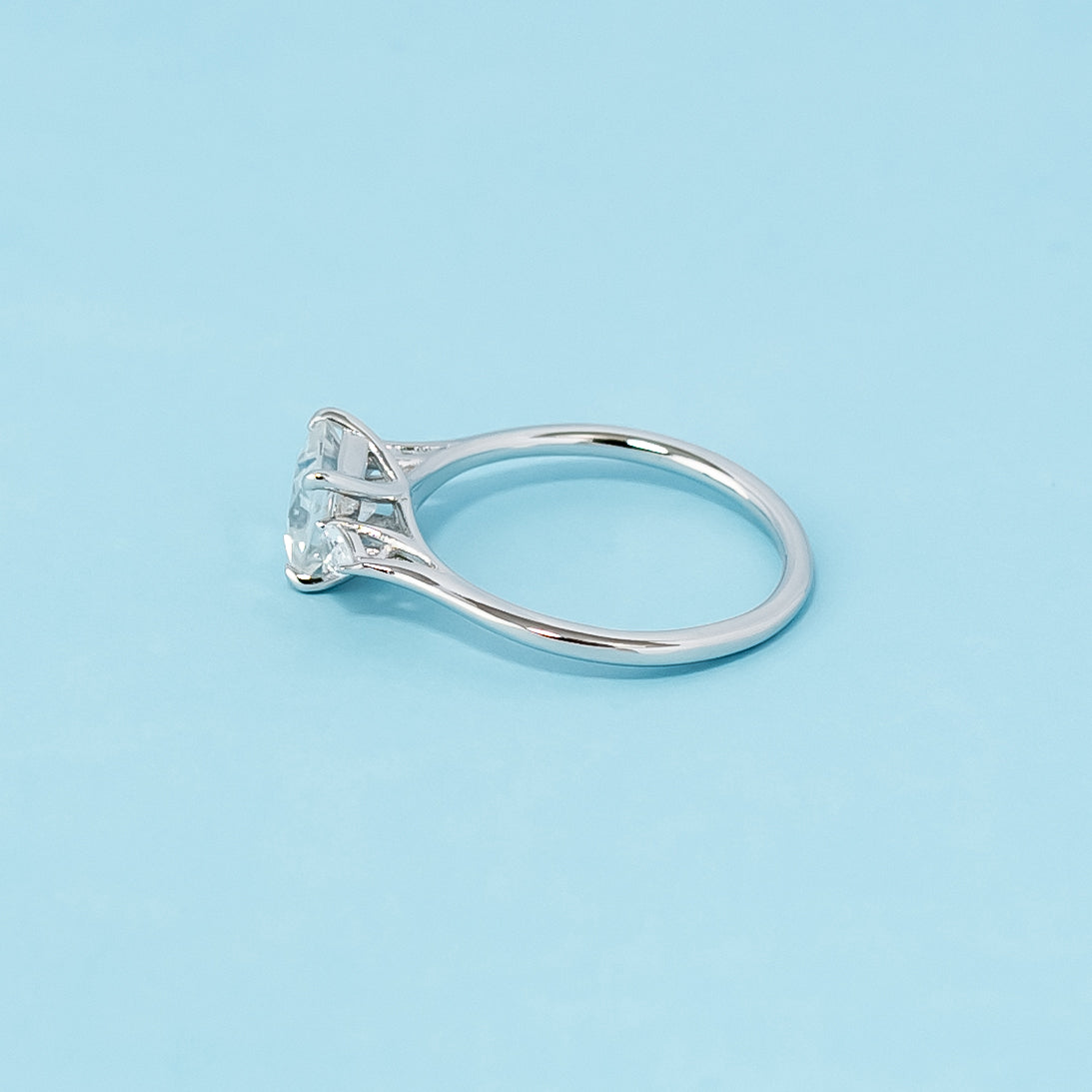 Modern and symbolic engagement ring set in 9ct white gold, featuring princess cut moissanites representing past, present, and future love.