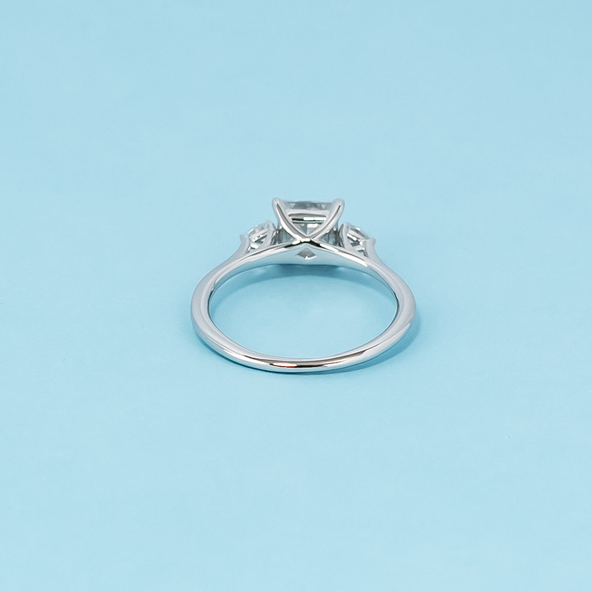 Luxurious 9ct white gold engagement ring with three beautiful princess cut moissanites in a timeless trilogy setting, symbolizing infinite love.