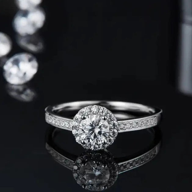 A captivating engagement ring featuring a 0.50ct moissanite surrounded by a halo of pave stones, set in a beautiful 9ct white gold band.