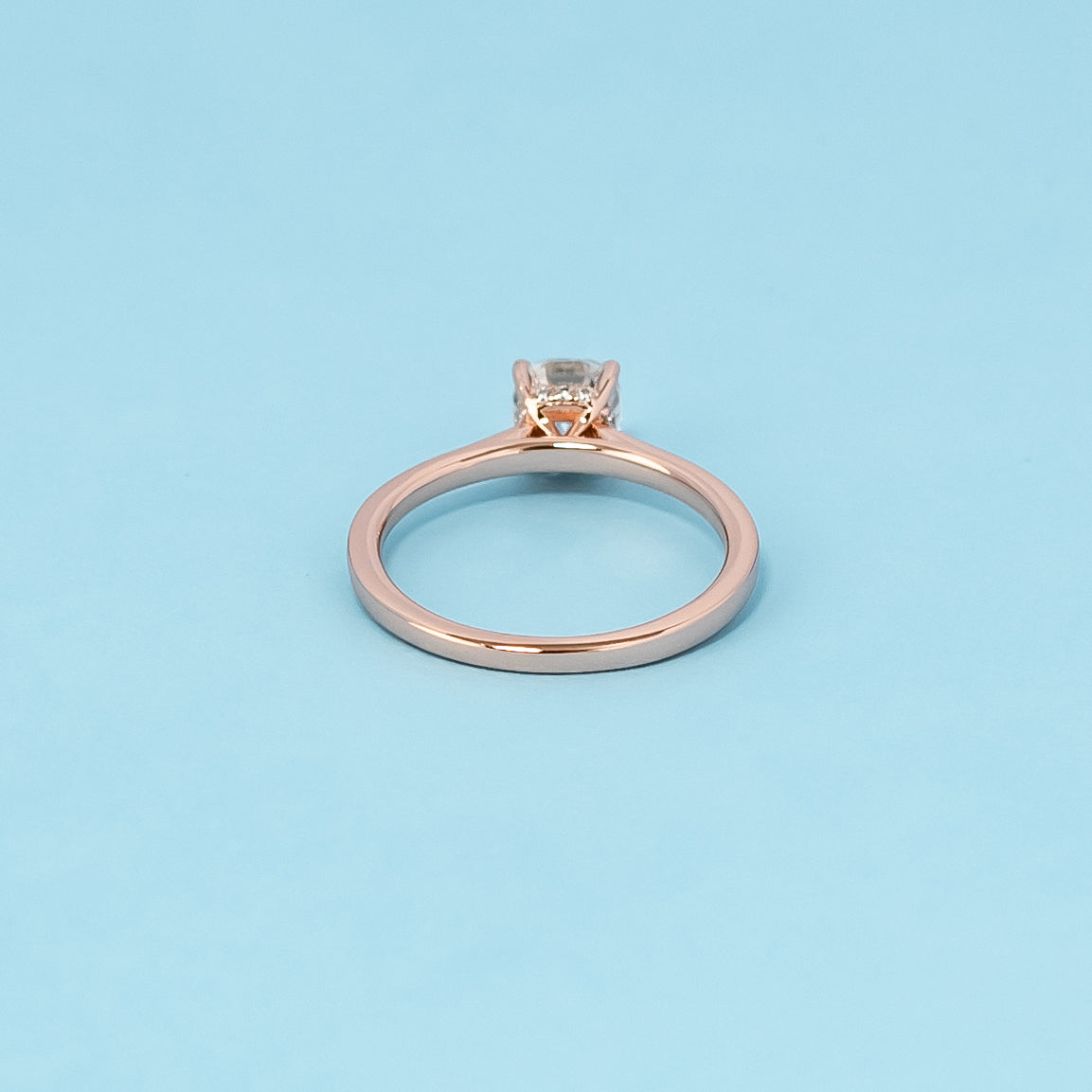 Luxurious 9ct rose gold engagement ring showcasing a brilliant cushion cut moissanite with a subtle and dazzling hidden halo.