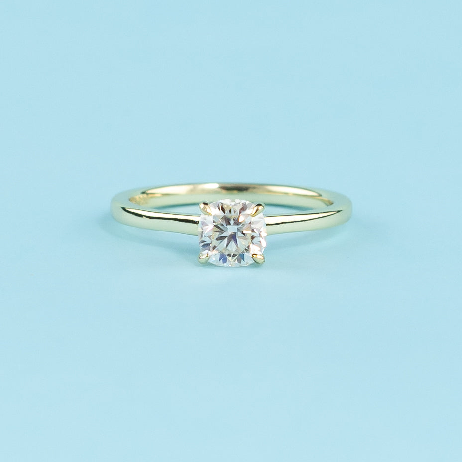 Showcases a beautiful cushion cut moissanite with a discreet hidden halo enhancing its brilliance.