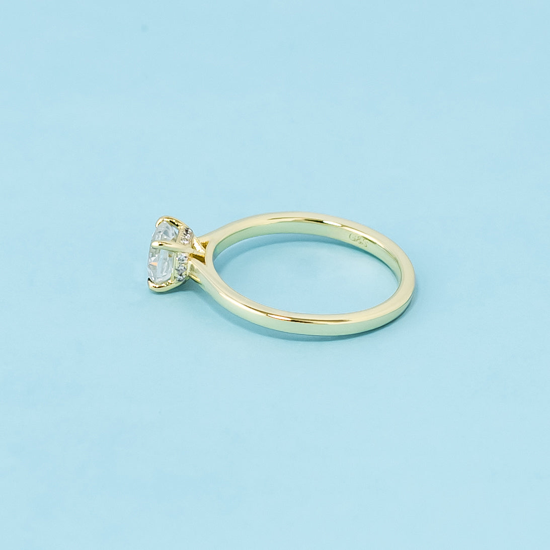 This 9ct yellow gold ring features a classic cushion cut moissanite with a hidden halo detail.