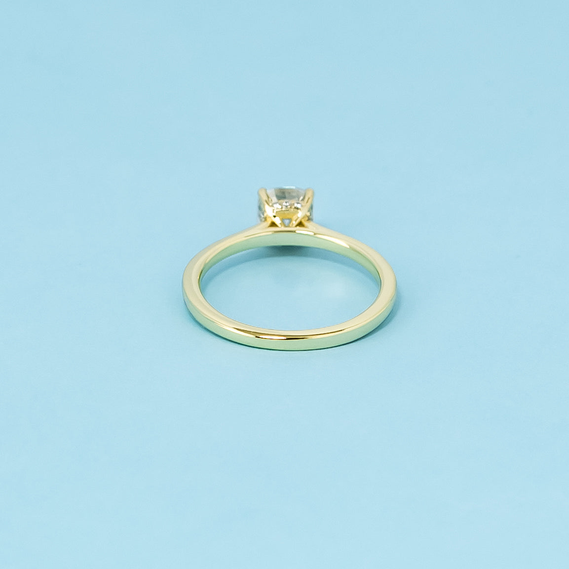 A sophisticated 9ct yellow gold engagement ring with a cushion cut moissanite and a hidden halo for added elegance and shine.
