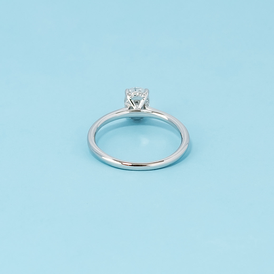 Luxurious 9ct white gold engagement ring with a discreet hidden halo setting that enhances the sparkle of the oval cut moissanite.