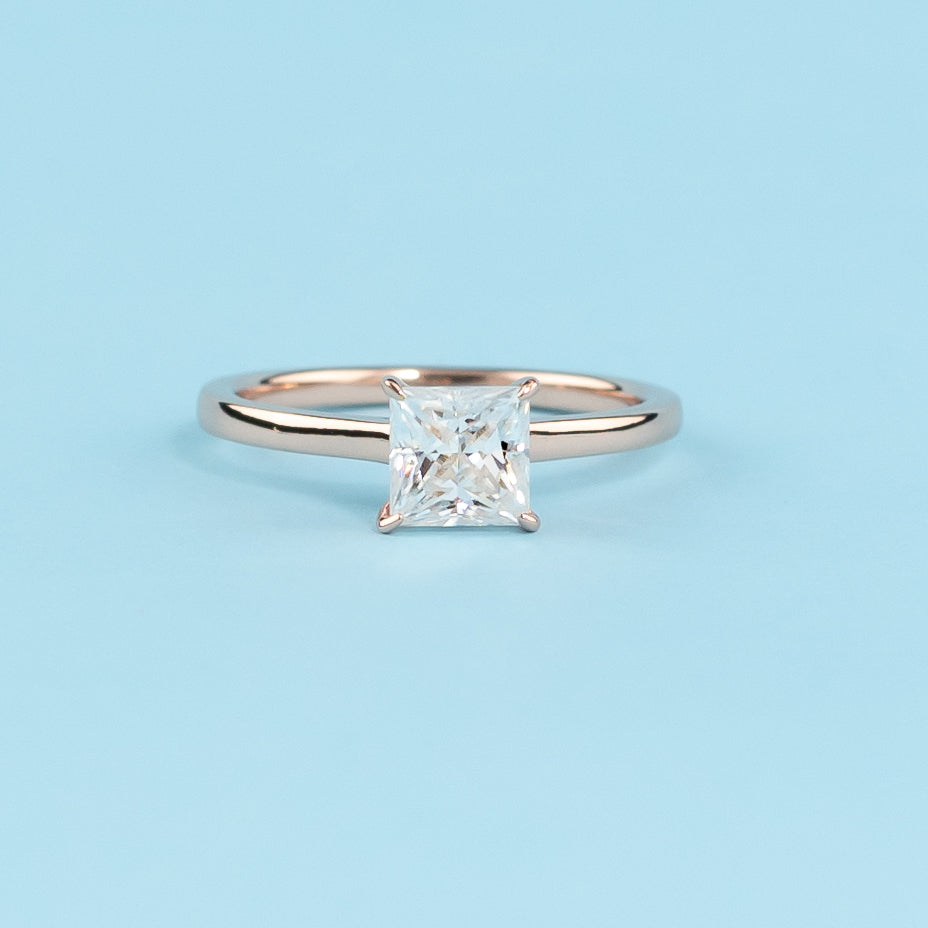 Elegant princess cut moissanite engagement ring with a delicate hidden halo, set in warm 9ct rose gold.