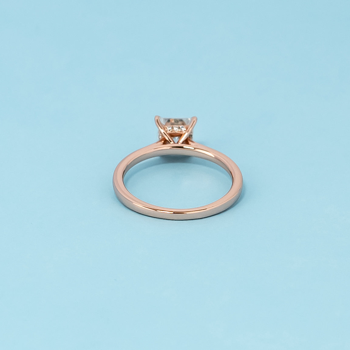 Luxurious 9ct rose gold engagement ring showcasing a brilliant princess cut moissanite with a subtle and dazzling hidden halo.