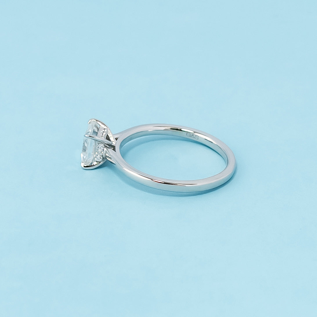 Modern and sophisticated engagement ring showcasing a princess cut moissanite with a unique hidden halo design, crafted in 9ct white gold.