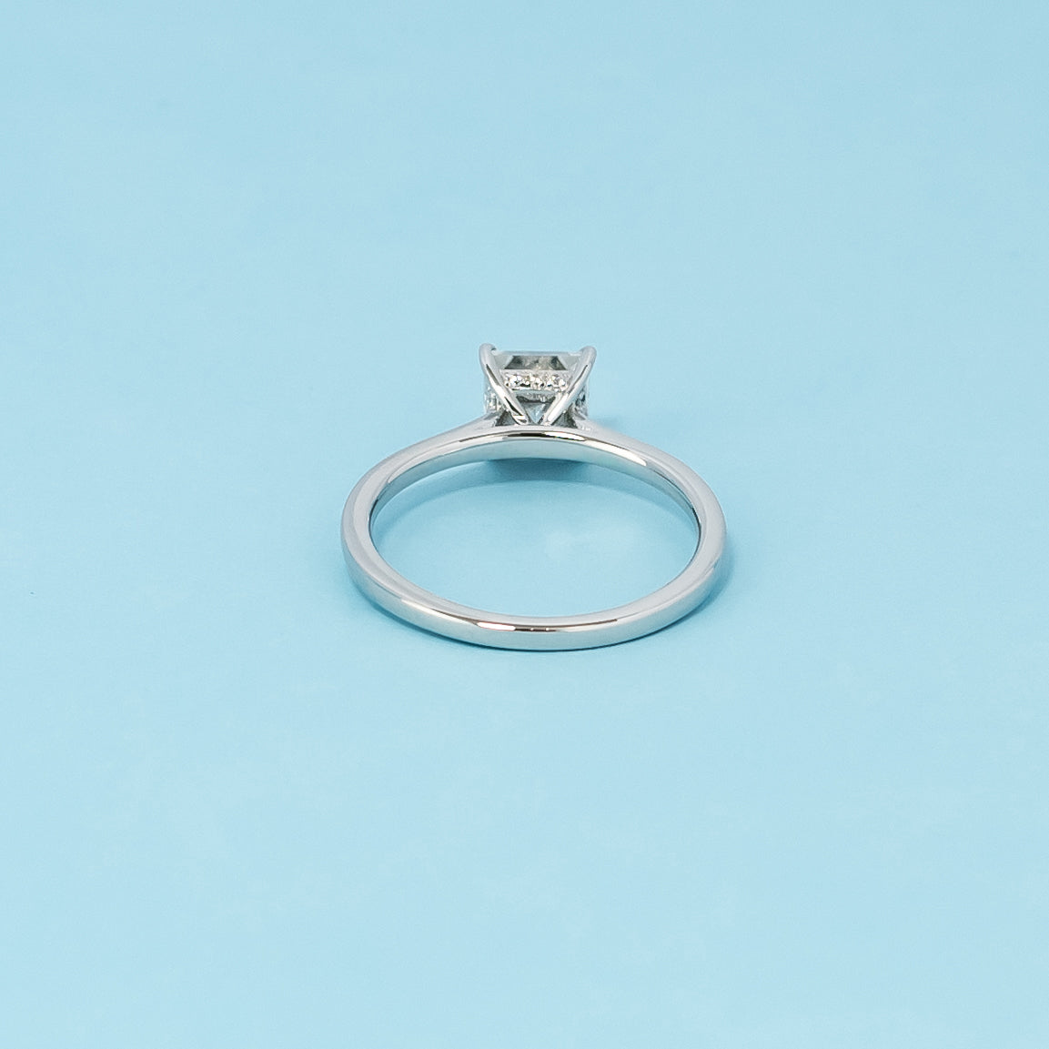 Luxurious 9ct white gold engagement ring with a discreet hidden halo setting that enhances the brilliance of the princess cut moissanite.