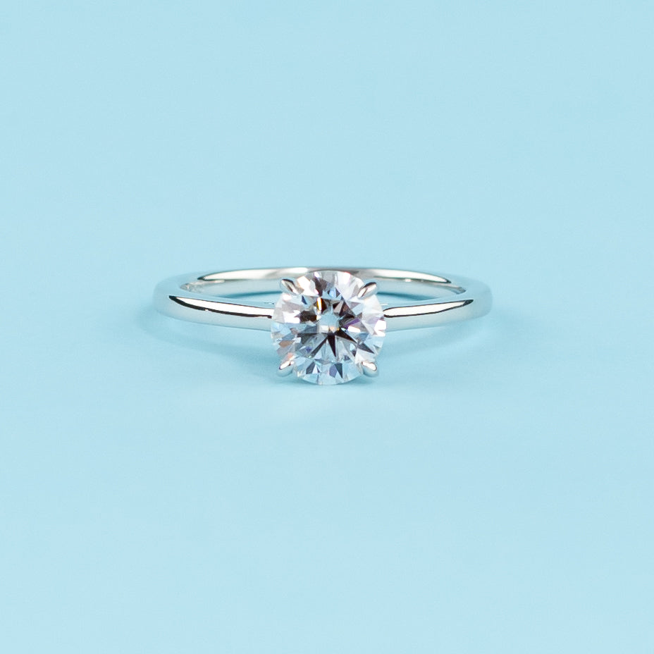 Elegant 9ct white gold engagement ring featuring a round brilliant moissanite with a hidden halo for extra sparkle.