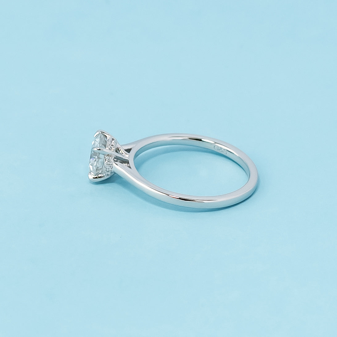 Modern and sophisticated engagement ring showcasing a round brilliant moissanite in a unique hidden halo design, crafted in 9ct white gold.