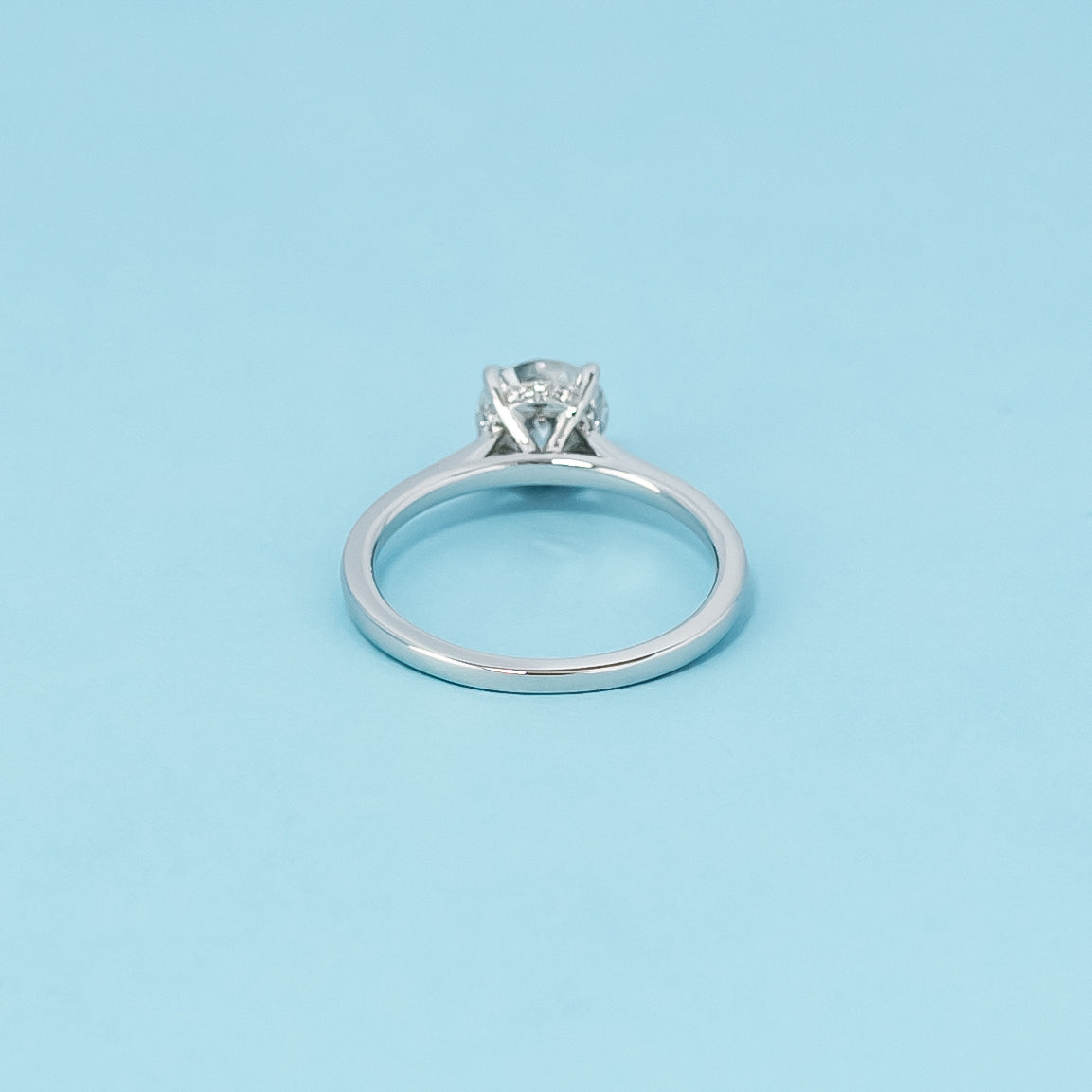 Luxurious 9ct white gold engagement ring with a discreet hidden halo setting that maximizes the brilliance of the round brilliant moissanite.