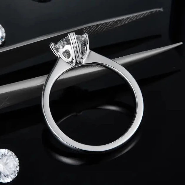 A timeless engagement ring in sterling silver, featuring a 1.00ct moissanite held by four heart-shaped prongs, adding a subtle touch of romance.