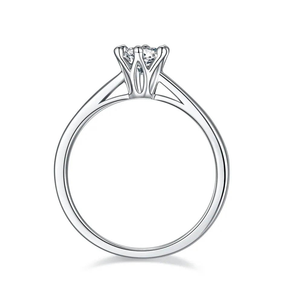This sterling silver ring features a 0.50ct moissanite held securely by six claws, with a delicate floral basket beneath, adding a touch of romance.