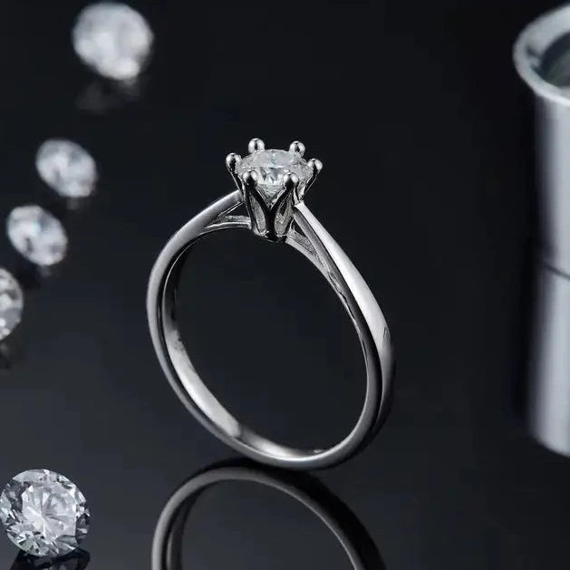 A charming engagement ring with a 0.50ct moissanite center stone set in a sterling silver band with a distinctive floral basket design.